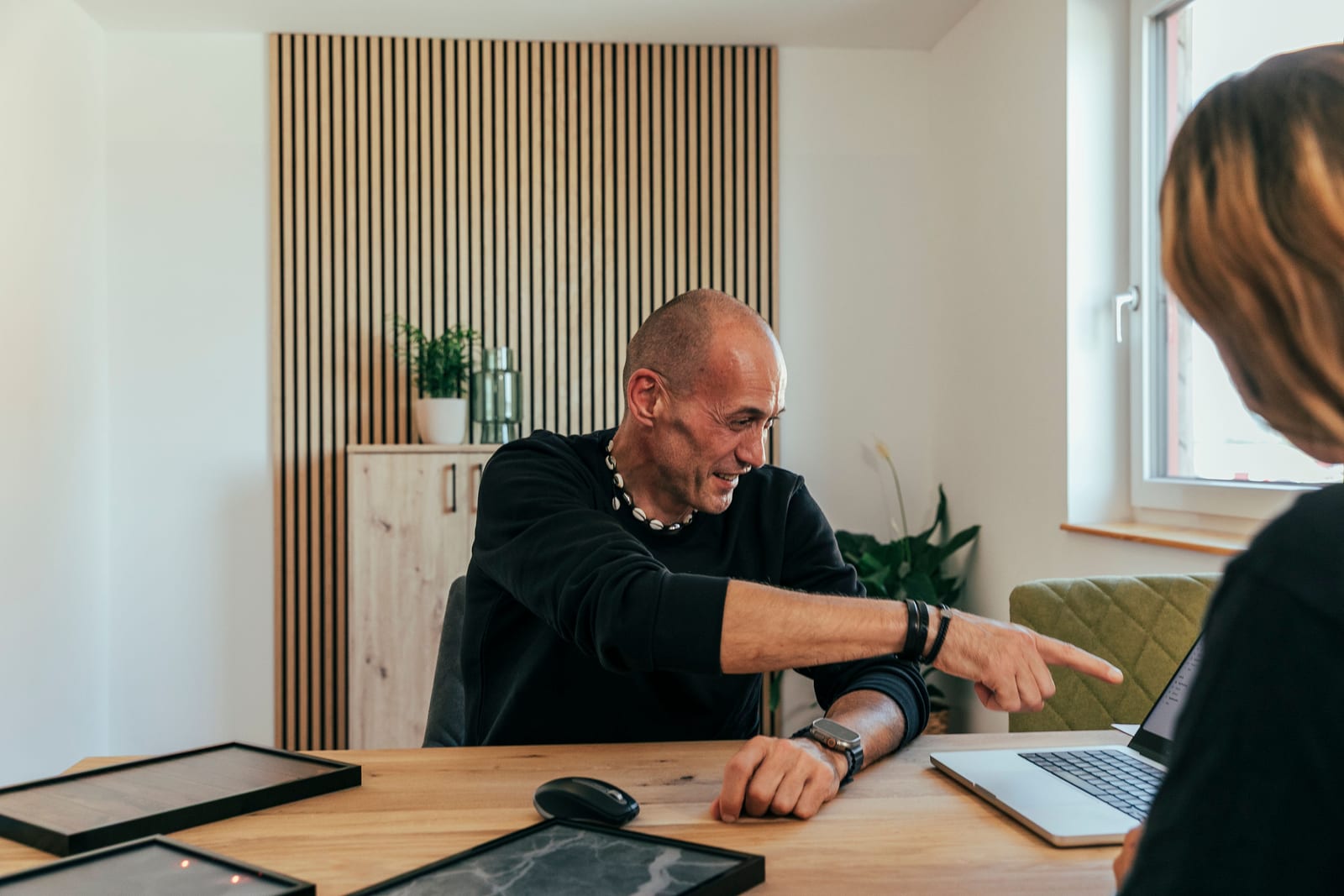 KLUW-Mitarbeiter deutet einer Kundin am Laptop auf die Fördersätze