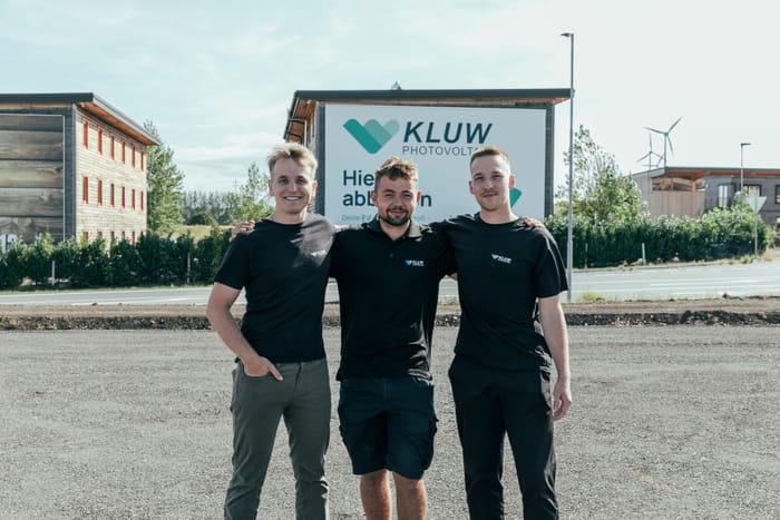 Die drei Gründer, Arm in Arm vor dem KLUW-Schild