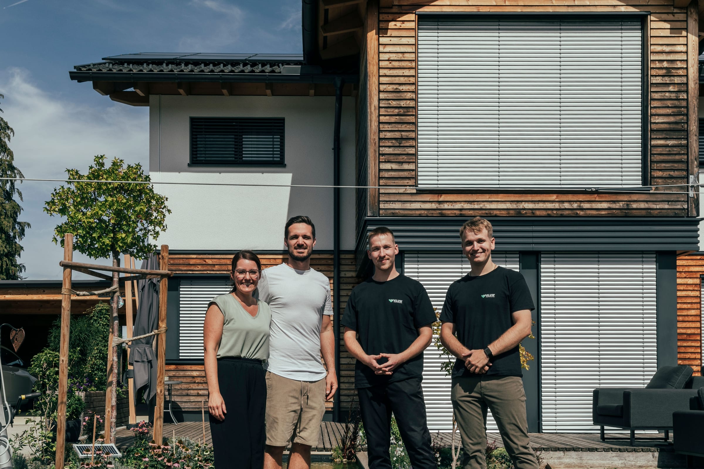Ein Kundenpaar und das KLUW-Team vor dem fertigen Haus