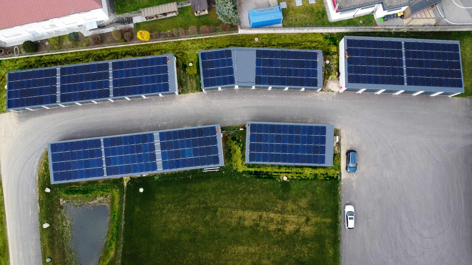 Luftaufnahme mehrerer Hallendächer voller PV-Module auf einem Betriebsgelände